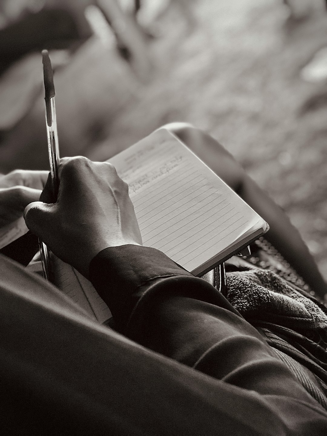 Una mano con un bolígrafo escribiendo en una libreta.